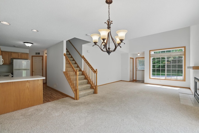 8741 Quarry Ridge Ln Unit H, Woodbury, MN 55125 - unfurnished living room with light colored carpet, stairway, a chandelier, and recessed lighting
