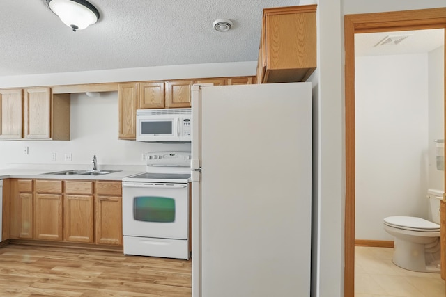 8741 Quarry Ridge Ln Unit H, Woodbury, MN 55125 - kitchen with white appliances, light countertops, a textured ceiling, and light wood-style flooring
