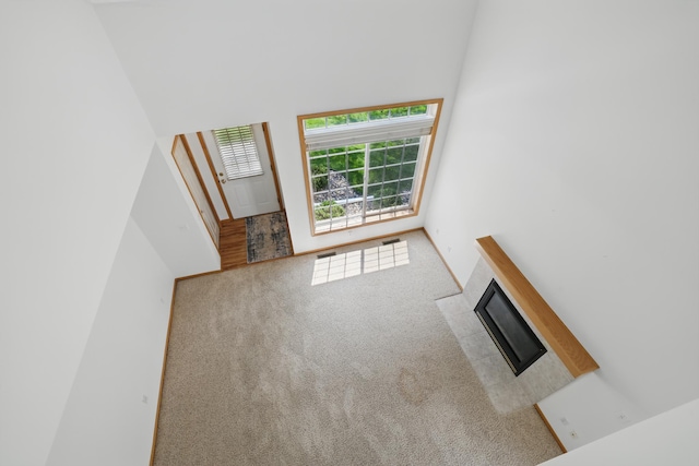 8741 Quarry Ridge Ln Unit H, Woodbury, MN 55125 - unfurnished living room featuring carpet floors, a fireplace, and a high ceiling