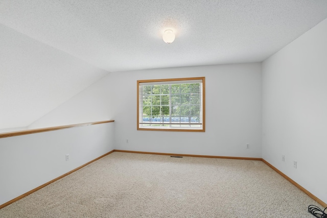 8741 Quarry Ridge Ln Unit H, Woodbury, MN 55125 - carpeted spare room featuring lofted ceiling and a textured ceiling