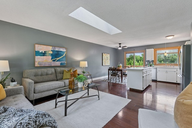 9700 265th St, Elko New Market, MN 55020 - living room featuring a skylight, dark wood-style floors, a textured ceiling, and ceiling fan