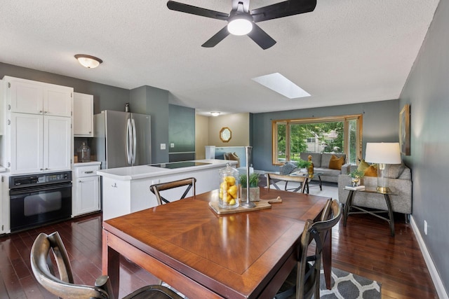 9700 265th St, Elko New Market, MN 55020 - dining space featuring dark wood-style floors, a textured ceiling, a skylight, and a ceiling fan