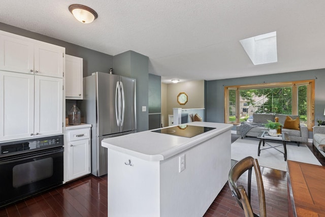 9700 265th St, Elko New Market, MN 55020 - kitchen featuring black appliances, open floor plan, dark wood finished floors, a skylight, and white cabinetry