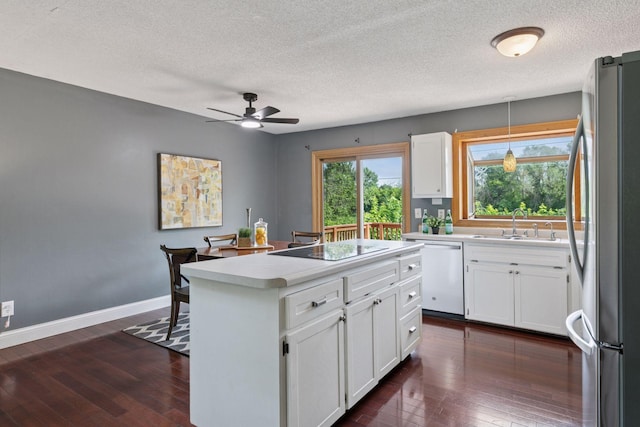 9700 265th St, Elko New Market, MN 55020 - kitchen with freestanding refrigerator, dishwasher, black electric stovetop, a textured ceiling, and a center island