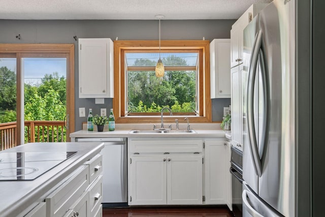 9700 265th St, Elko New Market, MN 55020 - kitchen featuring appliances with stainless steel finishes, white cabinets, light countertops, decorative light fixtures, and a textured ceiling