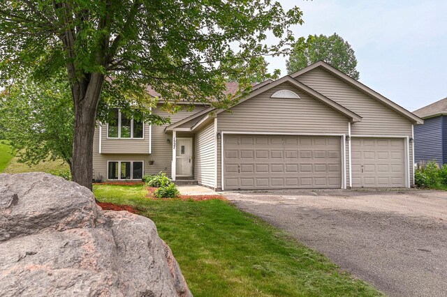 1527 Harvest Ln, Shakopee, MN 55379 - split level home with an attached garage, driveway, and a front lawn
