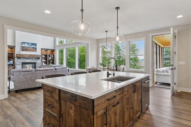 14217 Packard St NE, Ham Lake, MN 55304 - kitchen featuring light countertops, dark wood-style flooring, a stone fireplace, healthy amount of natural light, and recessed lighting