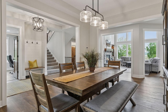 14217 Packard St NE, Ham Lake, MN 55304 - dining space with a chandelier, dark wood-style flooring, stairs, and a stone fireplace