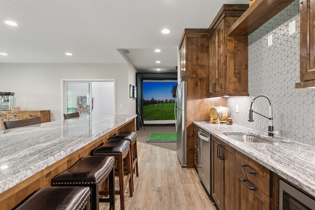 14217 Packard St NE, Ham Lake, MN 55304 - kitchen featuring stainless steel appliances, light wood-style flooring, light stone counters, a breakfast bar, and recessed lighting
