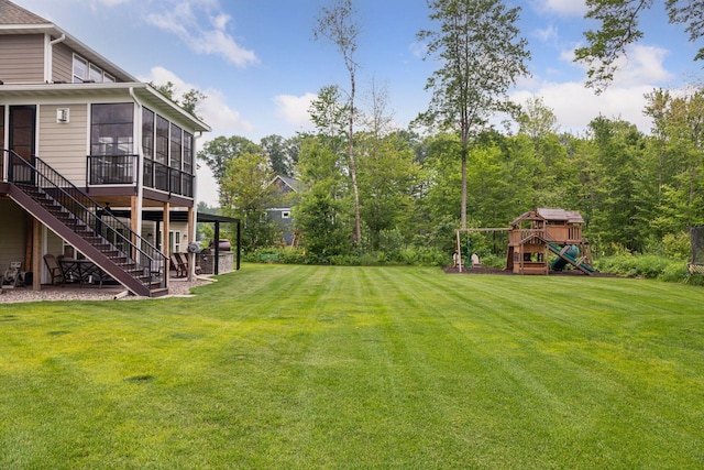 14217 Packard St NE, Ham Lake, MN 55304 - view of green lawn featuring a sunroom, a playground, and stairs
