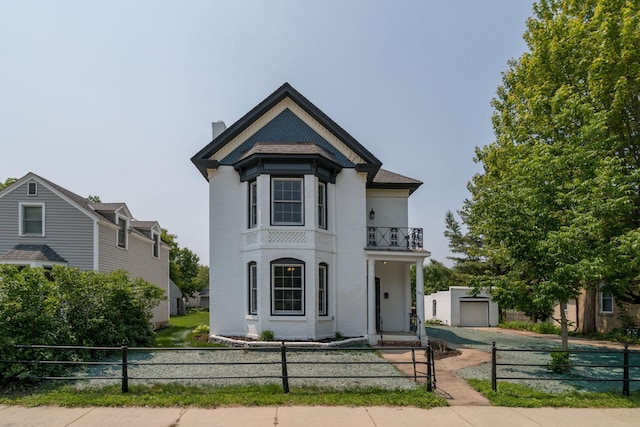 121 Hickory St, Chaska, MN 55318 - victorian home featuring a balcony, a fenced front yard, brick siding, and a chimney