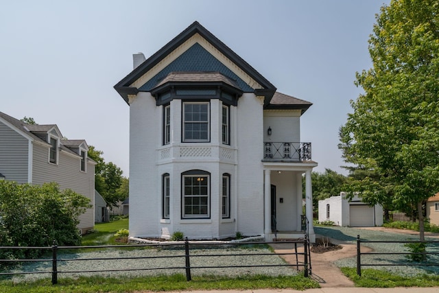 121 Hickory St, Chaska, MN 55318 - view of front of house with a balcony, a fenced front yard, brick siding, and a chimney