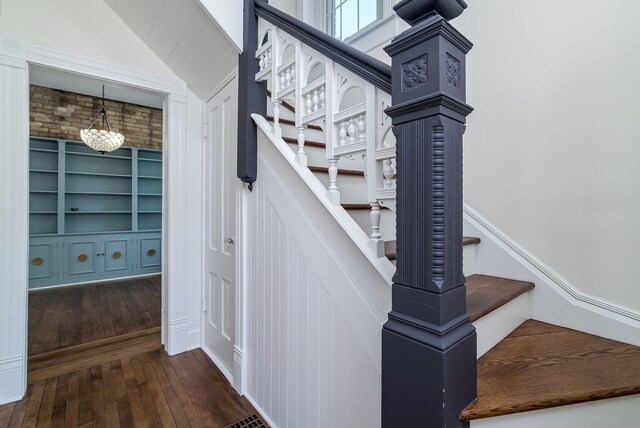 121 Hickory St, Chaska, MN 55318 - stairs with hardwood / wood-style flooring, vaulted ceiling, and built in shelves