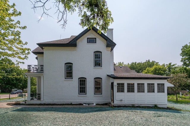 121 Hickory St, Chaska, MN 55318 - back of house featuring a balcony, a chimney, brick siding, and a shingled roof