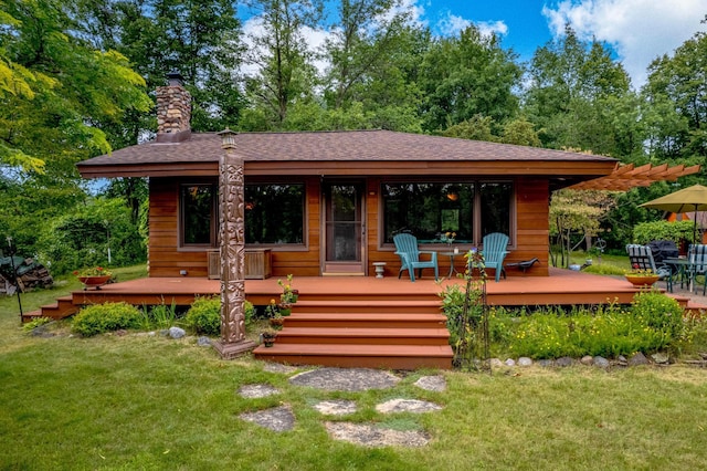 20907 Erickson Ln, Grantsburg, WI 54840 - rear view of house with a chimney, a lawn, roof with shingles, and a wooden deck