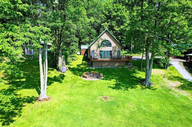 W6741 Lakewood Blvd, Dewey Twp, WI 54848 - view of front of house with a deck, a fire pit, and a front lawn