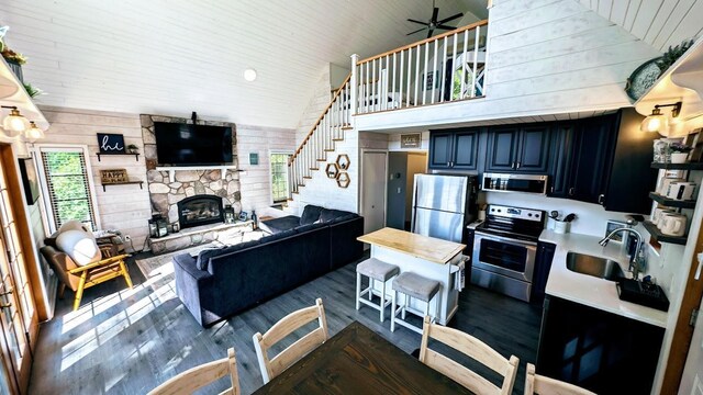 W6741 Lakewood Blvd, Dewey Twp, WI 54848 - living area featuring wood finished floors, ceiling fan, stairway, a fireplace, and wooden walls