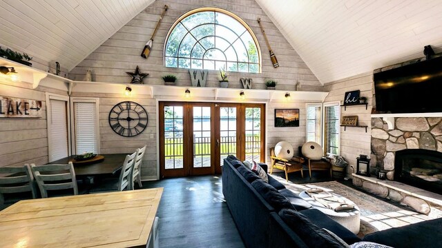 W6741 Lakewood Blvd, Dewey Twp, WI 54848 - living room with wooden walls, high vaulted ceiling, french doors, wood finished floors, and a stone fireplace