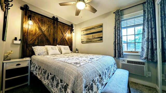 W6741 Lakewood Blvd, Dewey Twp, WI 54848 - carpeted bedroom with a barn door, a ceiling fan, and cooling unit