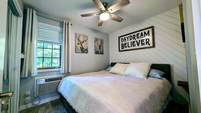 W6741 Lakewood Blvd, Dewey Twp, WI 54848 - carpeted bedroom featuring a wall mounted air conditioner, a ceiling fan, and wood walls