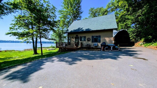 W6741 Lakewood Blvd, Dewey Twp, WI 54848 - view of front of property featuring a deck with water view, a carport, a front lawn, and driveway