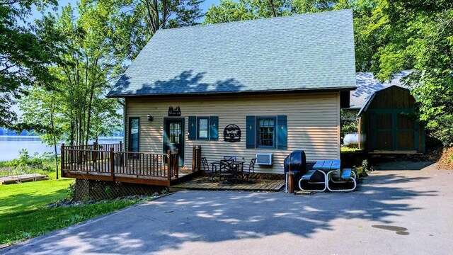 W6741 Lakewood Blvd, Dewey Twp, WI 54848 - view of front of house with a deck, a storage unit, and roof with shingles