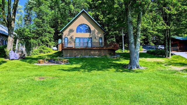 W6741 Lakewood Blvd, Dewey Twp, WI 54848 - view of front facade with a fire pit, a deck, and a front yard