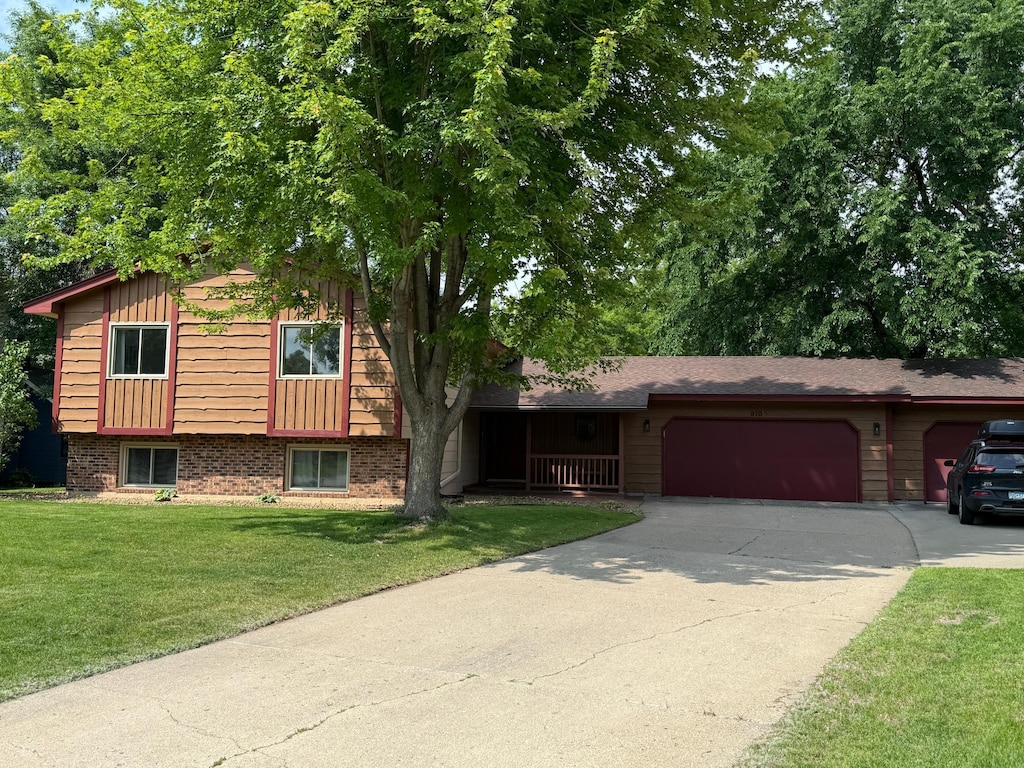 910 Penamint Ct, Chanhassen, MN 55317 - tri-level home featuring an attached garage, driveway, a front yard, and brick siding
