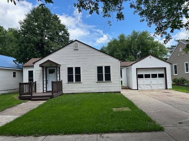 206 3rd St, Minneota, MN 56264 - view of front of home with an outbuilding, a garage, and a front lawn
