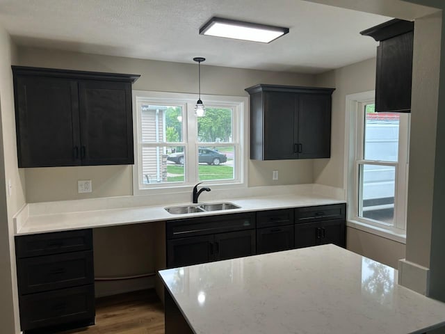 206 3rd St, Minneota, MN 56264 - kitchen with healthy amount of natural light, wood finished floors, light stone counters, and decorative light fixtures