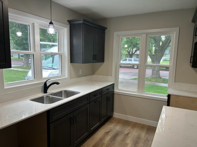 206 3rd St, Minneota, MN 56264 - kitchen with light wood finished floors, decorative light fixtures, and light stone countertops