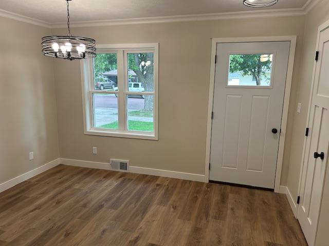 206 3rd St, Minneota, MN 56264 - entrance foyer with plenty of natural light, ornamental molding, a chandelier, and wood finished floors