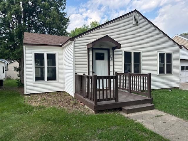 206 3rd St, Minneota, MN 56264 - bungalow-style home with a front yard, a wooden deck, and an attached garage