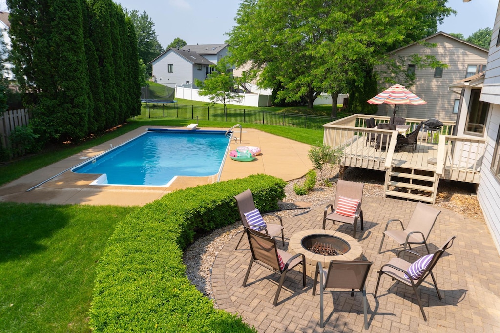 4731 Hazeltine Ln, Eagan, MN 55123 - view of swimming pool featuring an outdoor fire pit, a wooden deck, a patio area, and a residential view