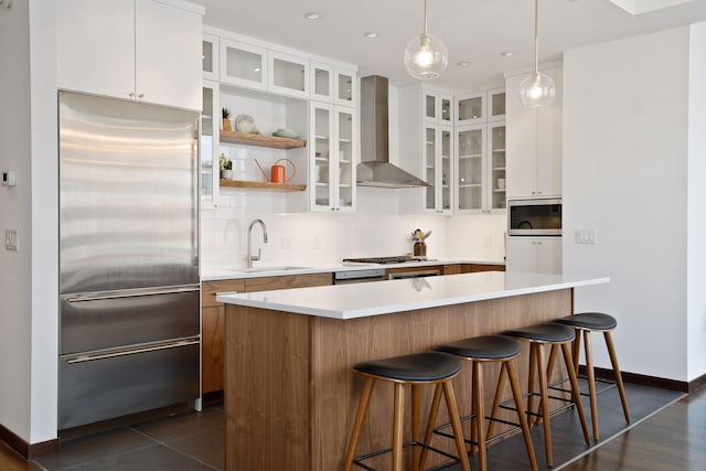 201 11th St Unit 530, Minneapolis, MN 55403 - kitchen with built in appliances, wall chimney exhaust hood, decorative backsplash, white cabinets, and a breakfast bar area