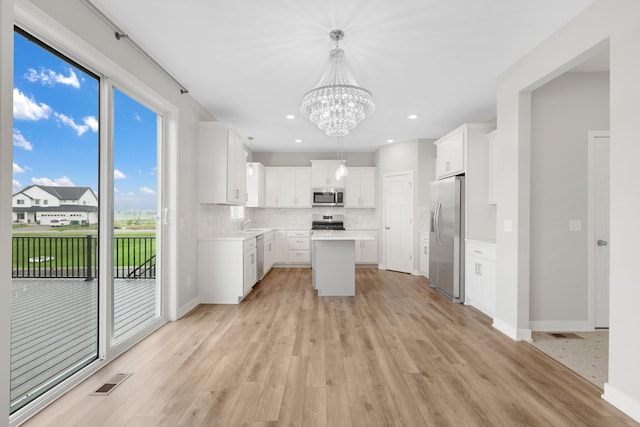 14320 Alder Way, Rosemount, MN 55068 - kitchen with stainless steel appliances, a chandelier, light wood-style floors, light countertops, and backsplash