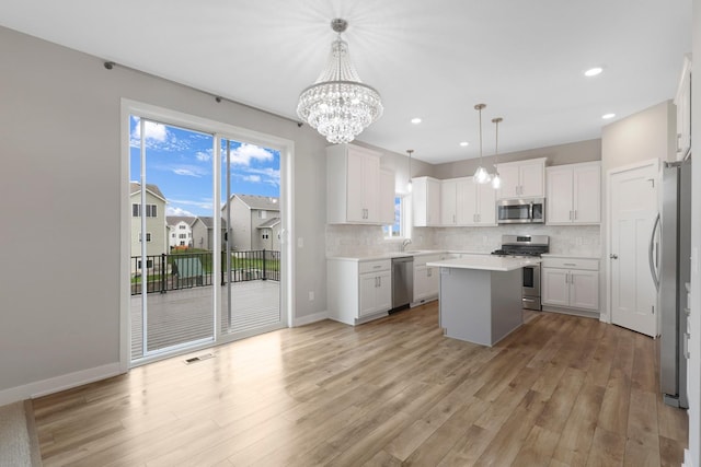 14320 Alder Way, Rosemount, MN 55068 - kitchen featuring appliances with stainless steel finishes, light wood-type flooring, a kitchen island, tasteful backsplash, and recessed lighting