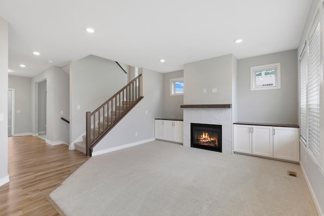 14320 Alder Way, Rosemount, MN 55068 - unfurnished living room with healthy amount of natural light, a fireplace, stairs, light wood finished floors, and recessed lighting