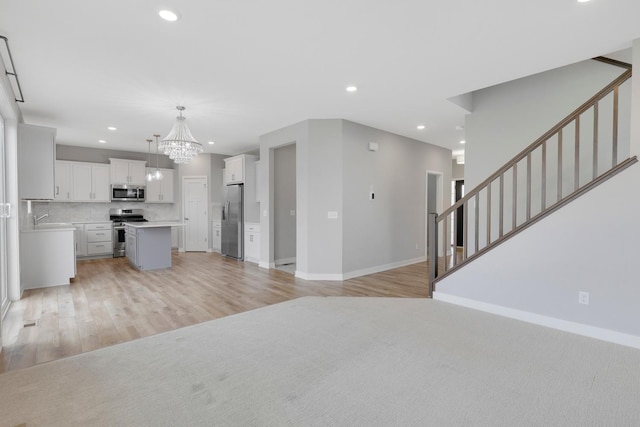 14320 Alder Way, Rosemount, MN 55068 - unfurnished living room with a chandelier, light wood-style flooring, recessed lighting, and stairway