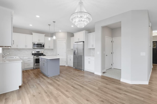 14320 Alder Way, Rosemount, MN 55068 - kitchen with appliances with stainless steel finishes, a kitchen island, tasteful backsplash, light countertops, and recessed lighting