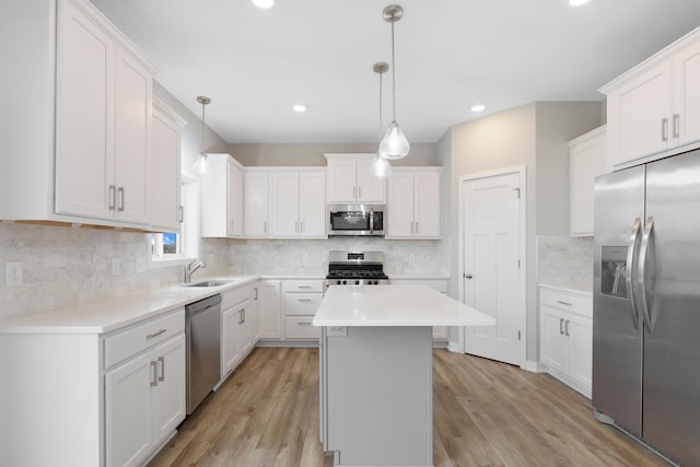14320 Alder Way, Rosemount, MN 55068 - kitchen featuring appliances with stainless steel finishes, light wood-style flooring, decorative backsplash, white cabinetry, and a kitchen island