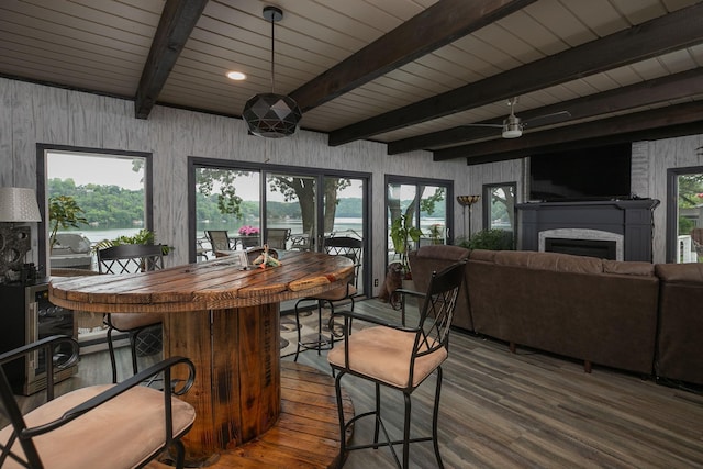 40536 Ryans Bay Rd, Zumbro Twp, MN 55991 - dining area with wood finished floors, a water view, a fireplace, a dry bar, and a wooden ceiling with exposed beams