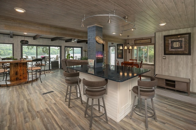 40536 Ryans Bay Rd, Zumbro Twp, MN 55991 - kitchen featuring a wood ceiling with exposed beams, wood finished floors, wooden walls, a kitchen breakfast bar, and a kitchen island