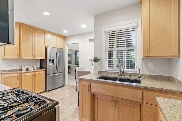 2709 Ewing Ave N, Robbinsdale, MN 55422 - kitchen with stainless steel fridge with ice dispenser, light brown cabinetry, black range with gas stovetop, recessed lighting, and light stone countertops