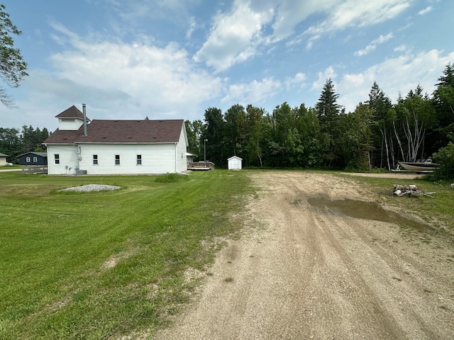 200 Park Ave, Williams, MN 56686 - view of side of home with a shed, dirt driveway, and a lawn