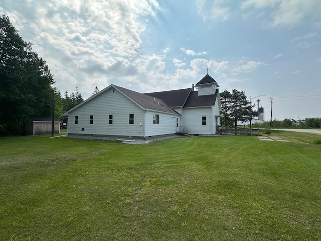 200 Park Ave, Williams, MN 56686 - rear view of house featuring a yard, a storage shed, and a shingled roof