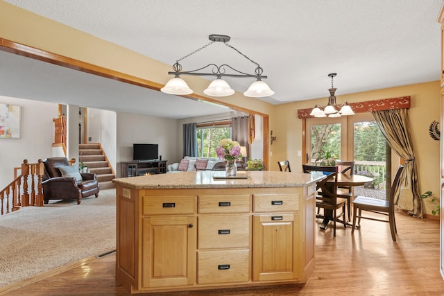13048 Jay St NW, Coon Rapids, MN 55448 - kitchen featuring a chandelier, light brown cabinetry, light wood-style floors, pendant lighting, and open floor plan