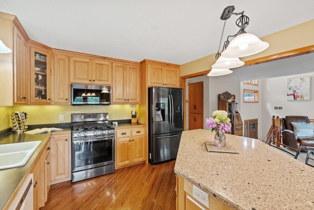13048 Jay St NW, Coon Rapids, MN 55448 - kitchen with appliances with stainless steel finishes, glass insert cabinets, light wood-type flooring, decorative light fixtures, and light stone countertops
