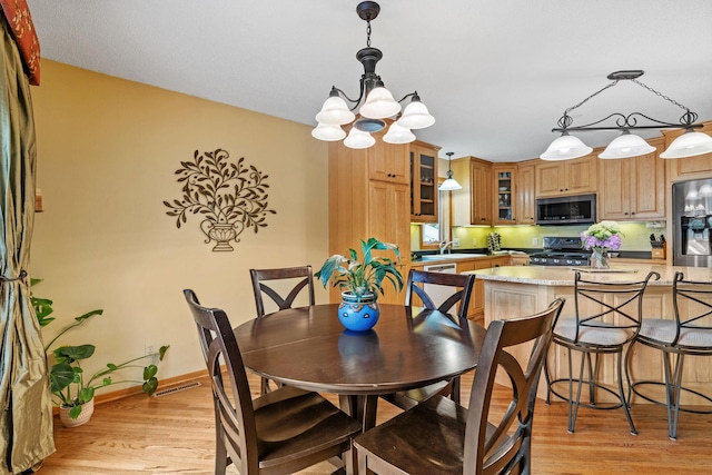 13048 Jay St NW, Coon Rapids, MN 55448 - dining area featuring a chandelier and light wood-style flooring