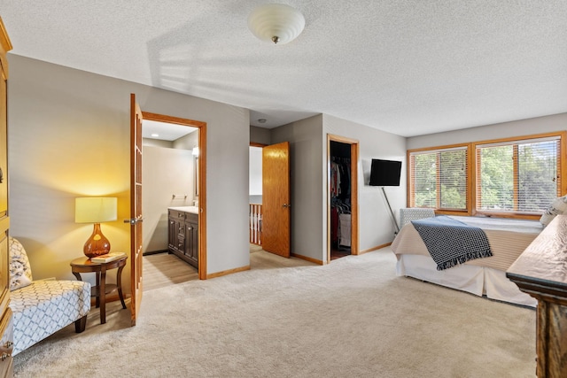 13048 Jay St NW, Coon Rapids, MN 55448 - bedroom with light carpet, a textured ceiling, connected bathroom, and a spacious closet